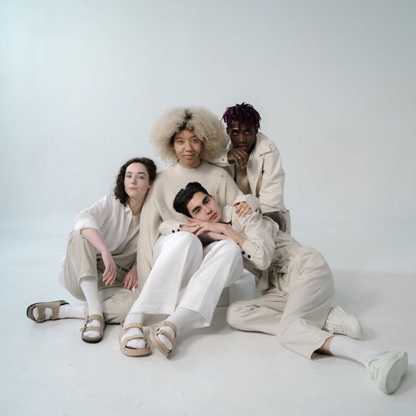 Group of diverse people sitting comfortably in a bright studio.